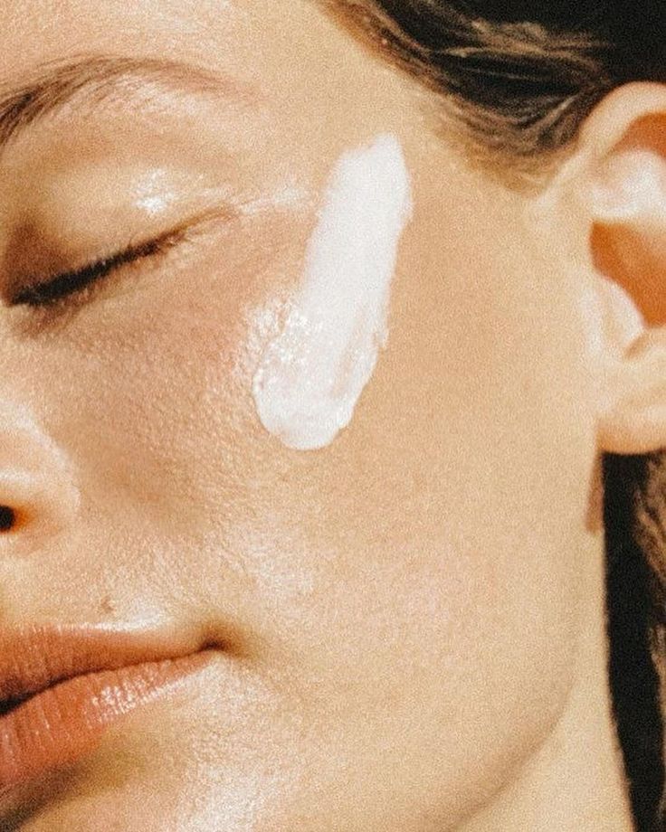 Close-up of a person applying cream to their face