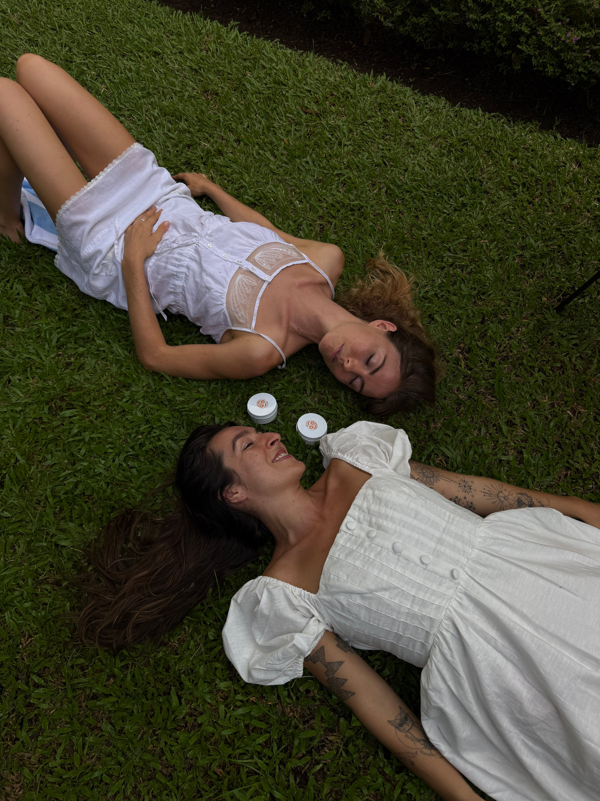 girls laying on grass with skincare | yinera tallow skincare